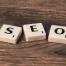 Scrabble tiles on brown table spelling out SEO