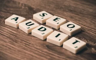 Scrabble tiles on brown table, spelling out SEO audit