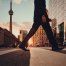 low angle shot of man crossing Toronto street with CN Tower visible in background