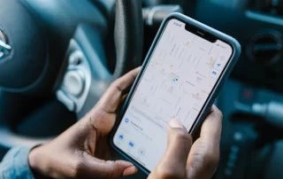 person using Google maps on smartphone while in car