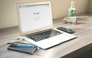 laptop on desk displaying Google search