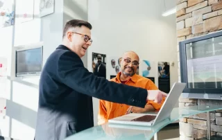 two colleagues looking at laptop