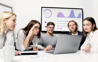 team of colleagues watching presentation on laptop