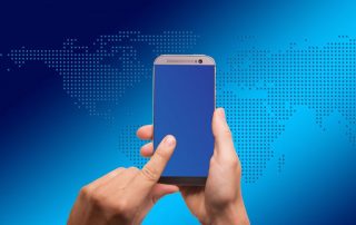 international SEO concept image - hands holding smartphone in front of stylized world map