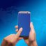 international SEO concept image - hands holding smartphone in front of stylized world map