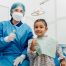 dentist and child patient giving “thumbs up” sign